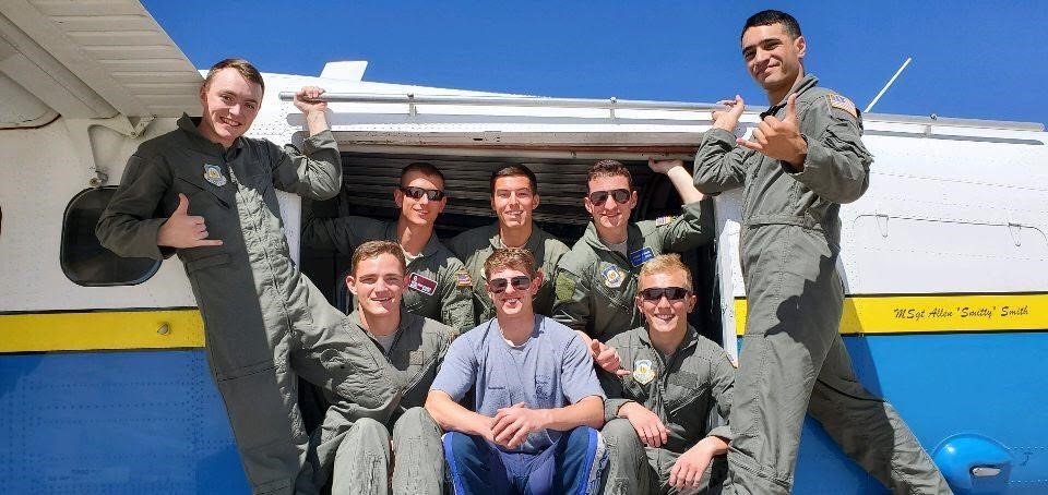 Cadets in the AFA Freefall Program pose in front of a plane.